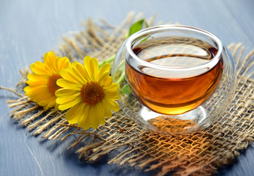pexels-photo-1638280-1638280-1 Glass cup of herbal tea with yellow flowers on a textured background.